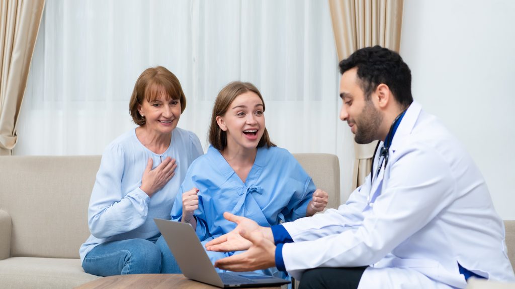 a doctor showing a woman something on the laptop to a woman